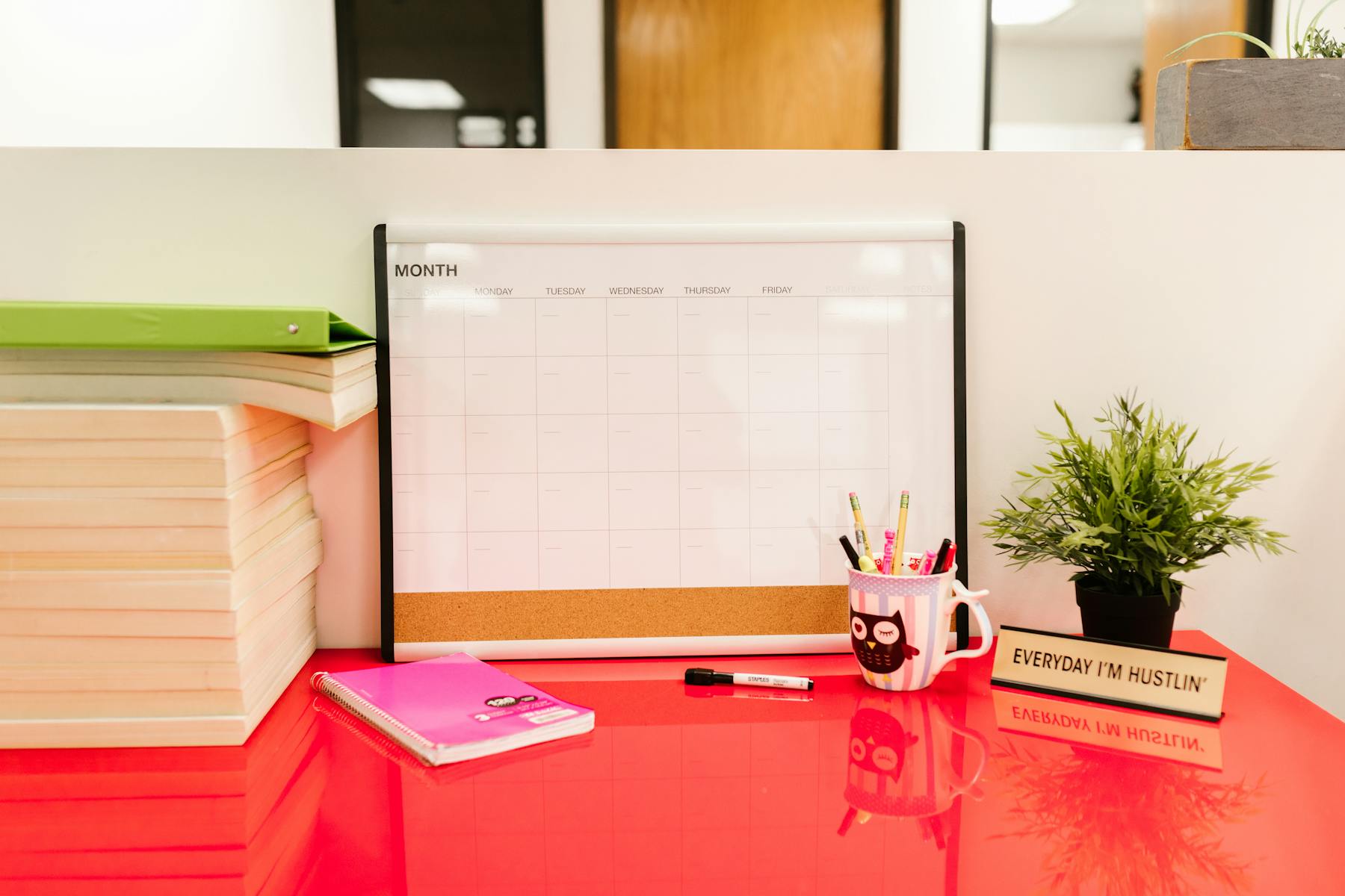 A desk workspace arranged around a paper calendar and work tools.